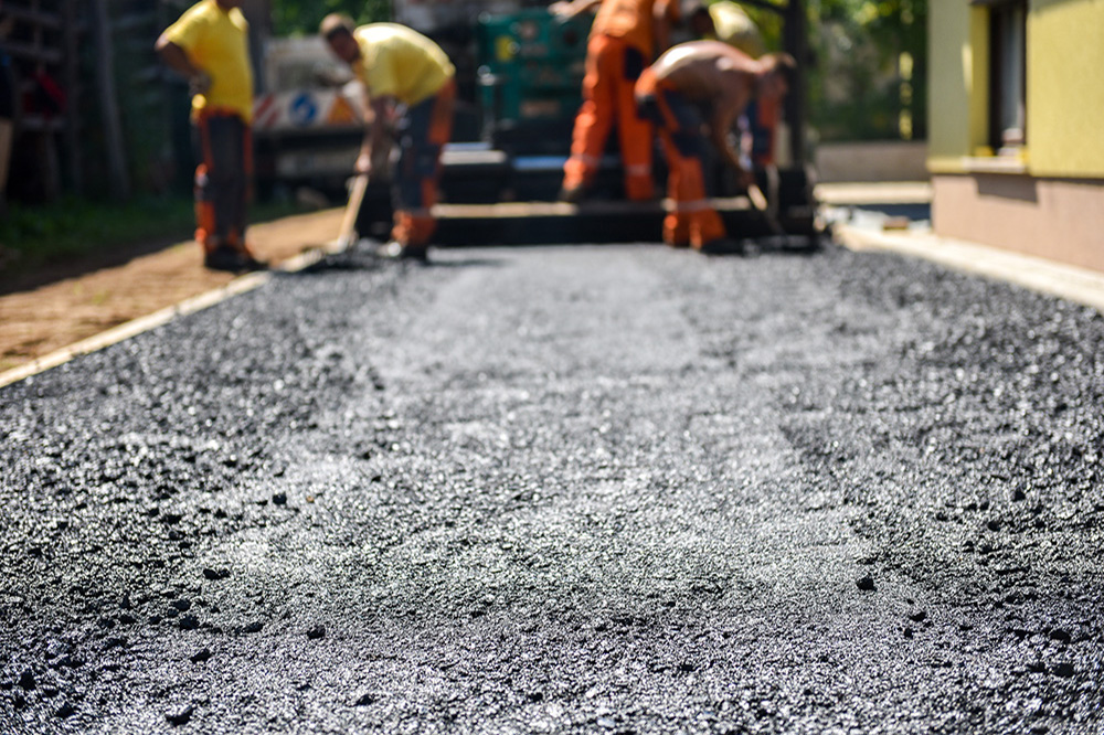 Team of Workers making and constructing asphalt road constructio Asphalt